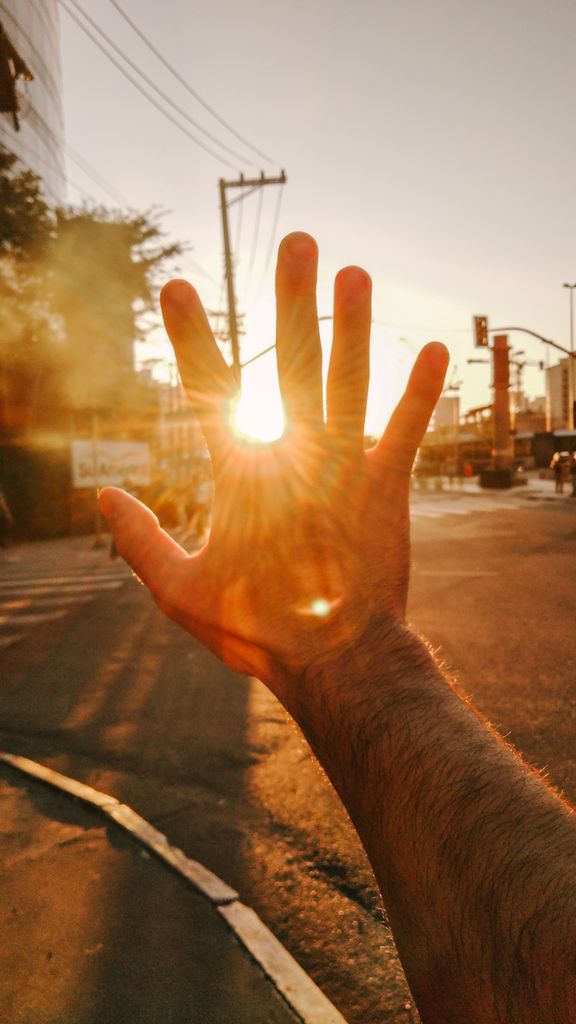 una mano que tapa el sol por el intenso sol